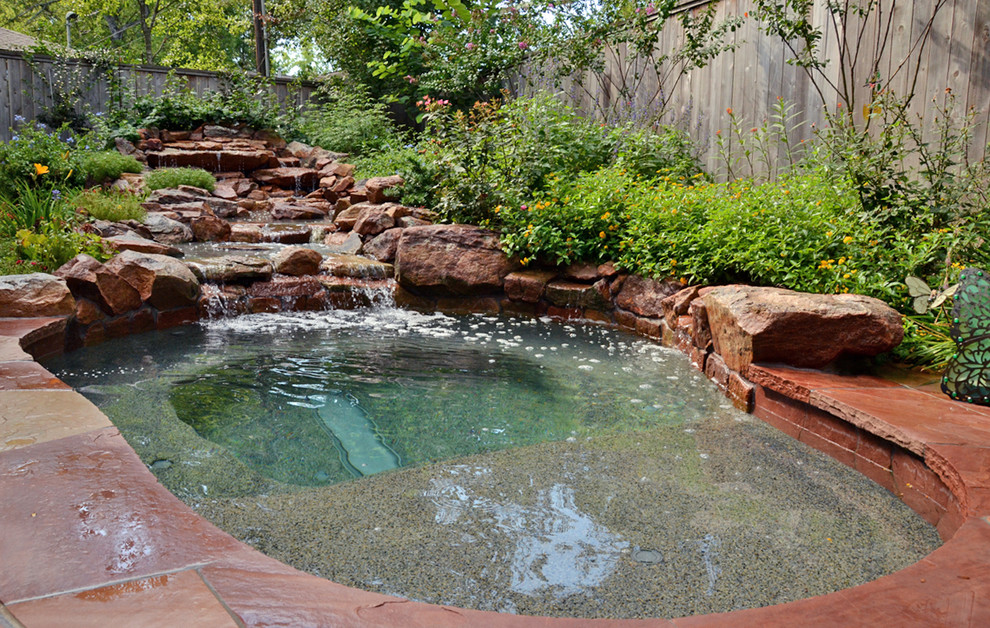 Design ideas for a small country backyard custom-shaped pool in Houston with a hot tub and natural stone pavers.