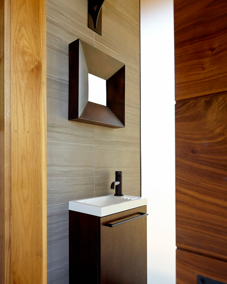 This is an example of a small modern powder room in San Francisco with flat-panel cabinets, dark wood cabinets, gray tile, stone tile and a drop-in sink.