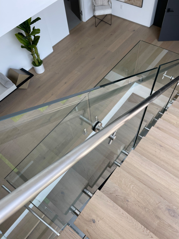 Идея дизайна: лестница в стиле модернизм с стеклянными подступенками и стеклянными перилами