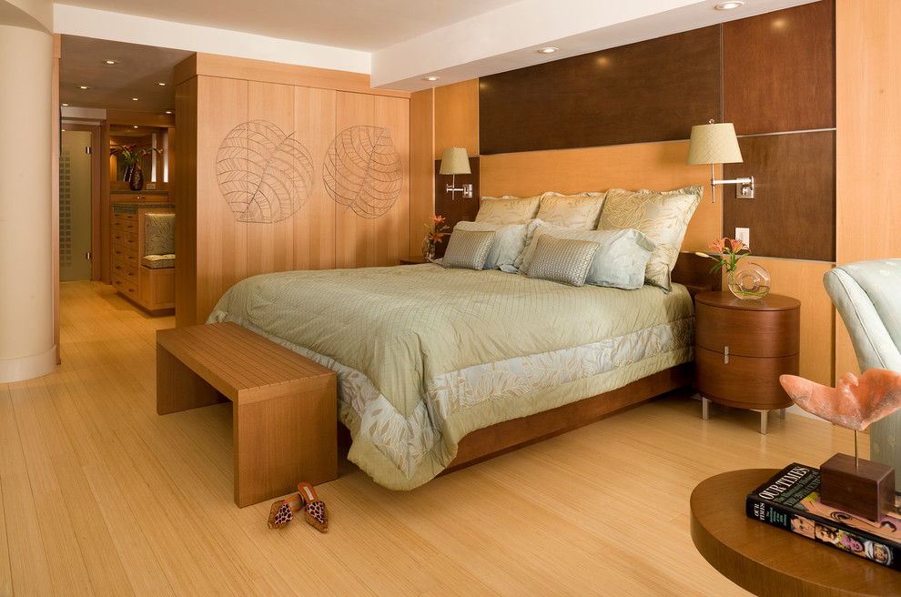 This is an example of a contemporary bedroom in Miami with beige walls and medium hardwood floors.
