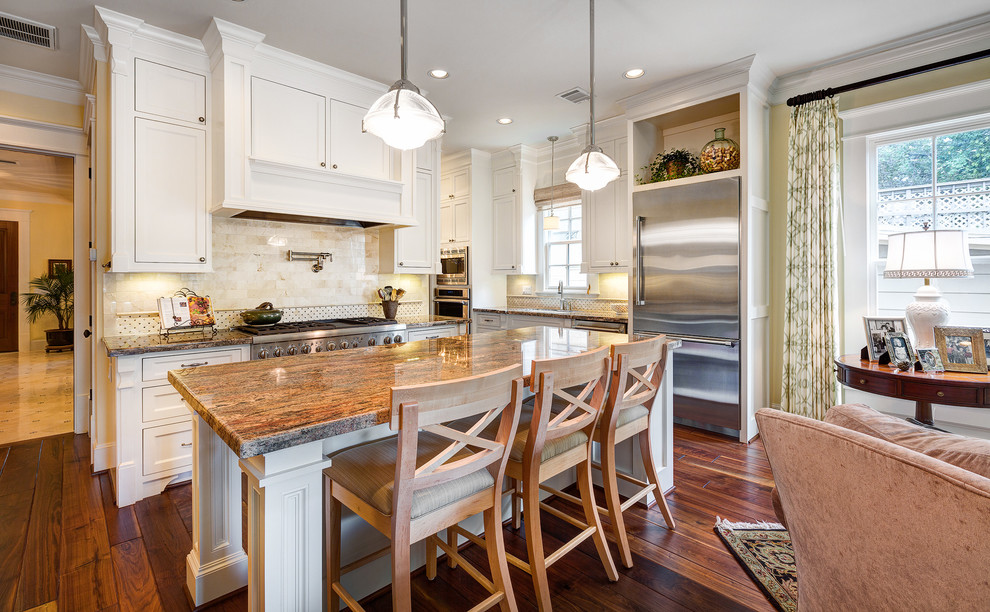 Traditional open plan kitchen in Houston with recessed-panel cabinets, white cabinets, granite benchtops, beige splashback, stainless steel appliances and stone tile splashback.