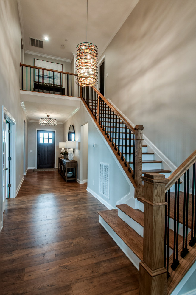 Photo of a mid-sized transitional foyer in Nashville with grey walls, medium hardwood floors, a single front door, a dark wood front door, brown floor and vaulted.