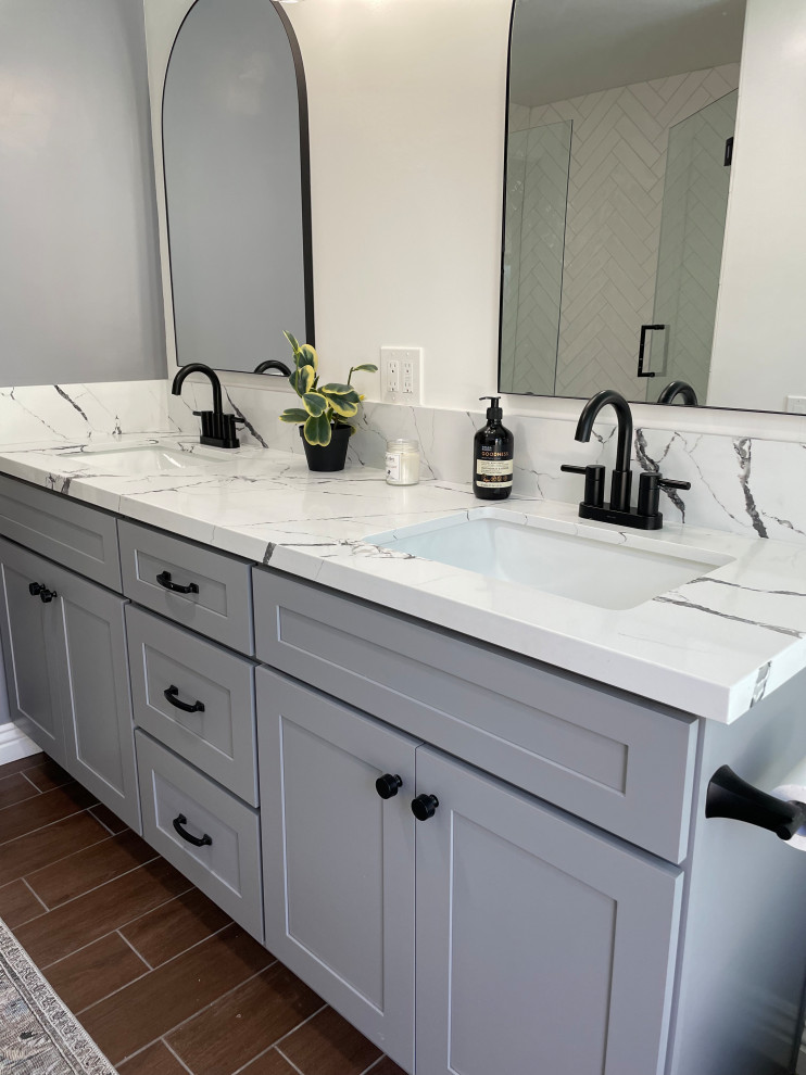 Inspiration for a medium sized rural grey and black family bathroom in Los Angeles with shaker cabinets, grey cabinets, an alcove shower, a one-piece toilet, white tiles, porcelain tiles, white walls, porcelain flooring, a submerged sink, engineered stone worktops, brown floors, a hinged door, black worktops, double sinks and a built in vanity unit.