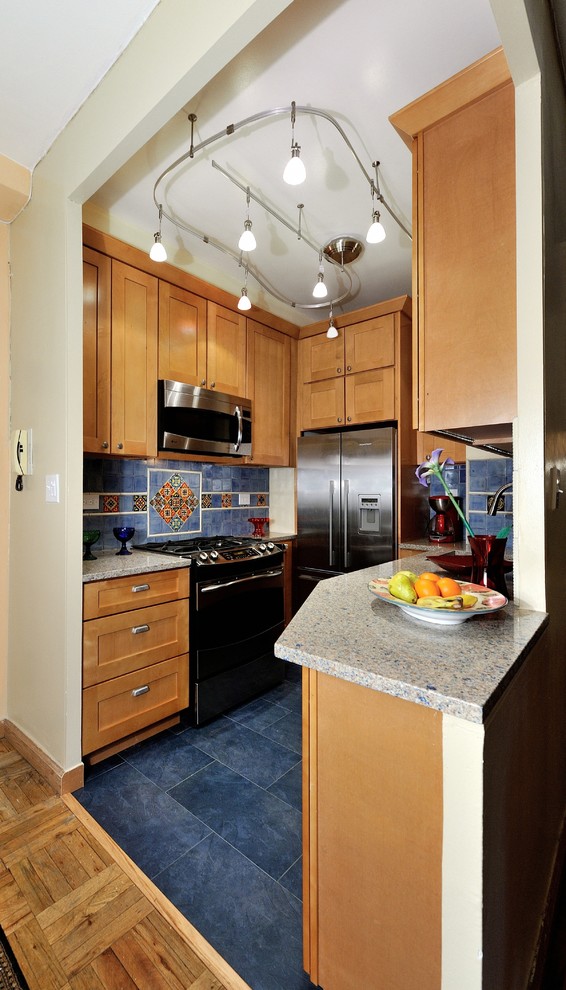 Small mediterranean u-shaped separate kitchen in New York with raised-panel cabinets, light wood cabinets, blue splashback, ceramic splashback, stainless steel appliances, recycled glass benchtops, porcelain floors and an undermount sink.