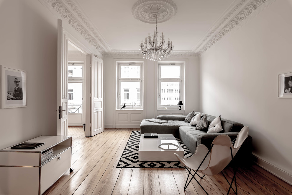 Inspiration for a scandinavian living room in Hamburg with white walls, medium hardwood floors and brown floor.