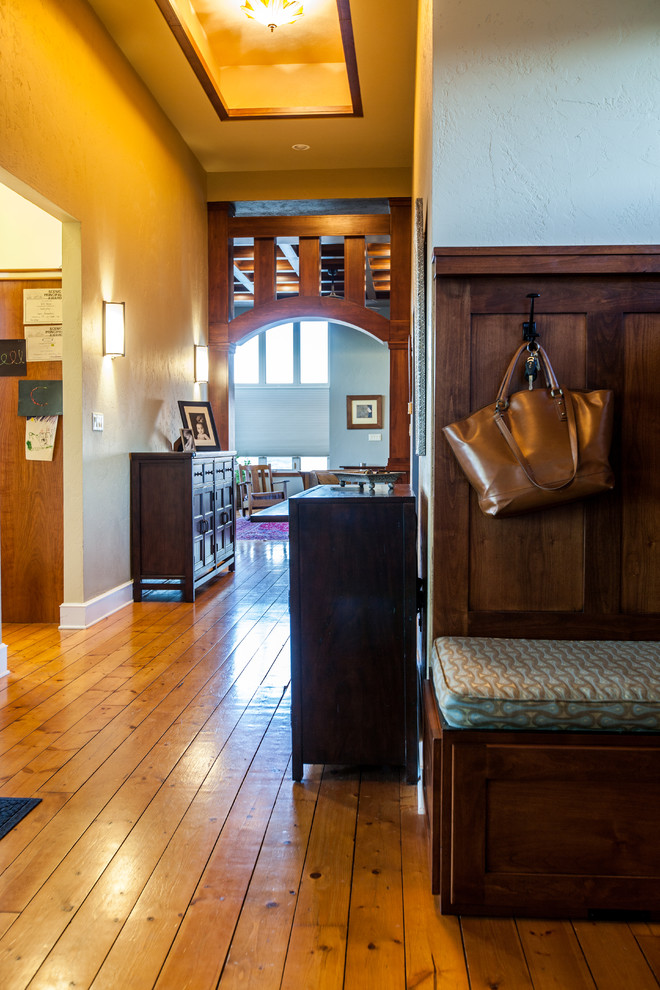 This is an example of a mid-sized arts and crafts foyer in Denver with beige walls, medium hardwood floors, a double front door, a medium wood front door and yellow floor.