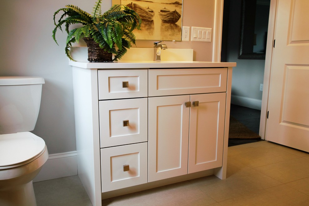 Design ideas for a mid-sized transitional powder room in Boston with shaker cabinets, white cabinets, a two-piece toilet, beige walls, porcelain floors, an undermount sink, granite benchtops and beige floor.
