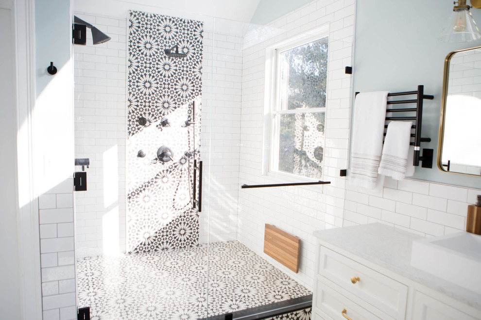 This is an example of a large mediterranean master wet room bathroom in Boston with shaker cabinets, white cabinets, a freestanding tub, a two-piece toilet, black and white tile, subway tile, blue walls, cement tiles, a vessel sink, marble benchtops, black floor, a hinged shower door and white benchtops.