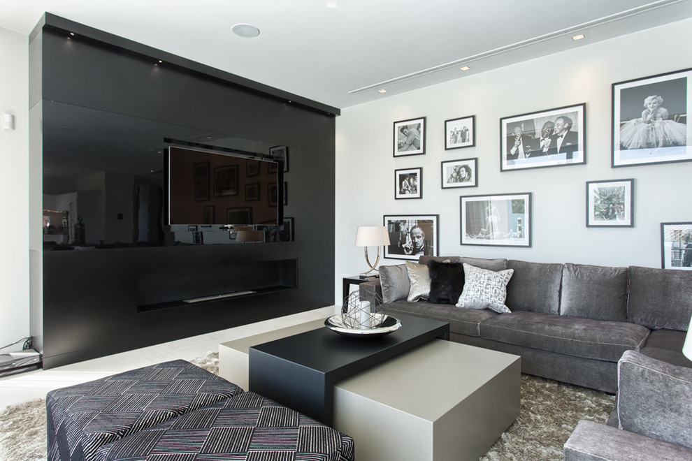 This is an example of a contemporary home theatre in Other with black walls and a built-in media wall.