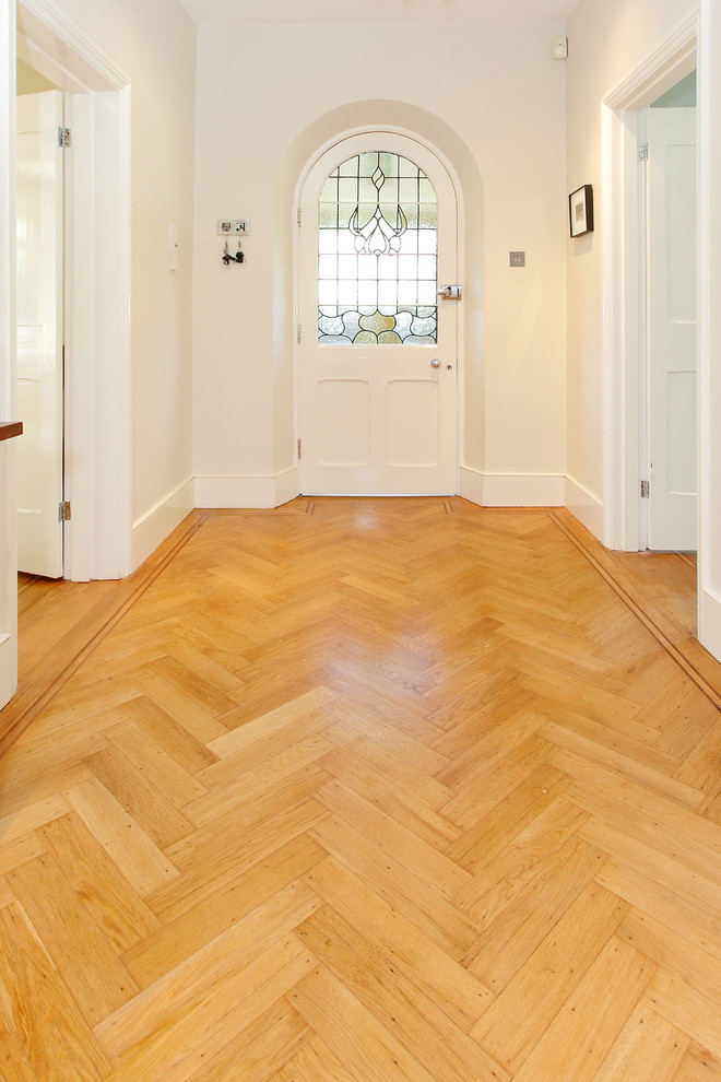 This is an example of a mid-sized traditional hallway in Surrey with white walls and medium hardwood floors.