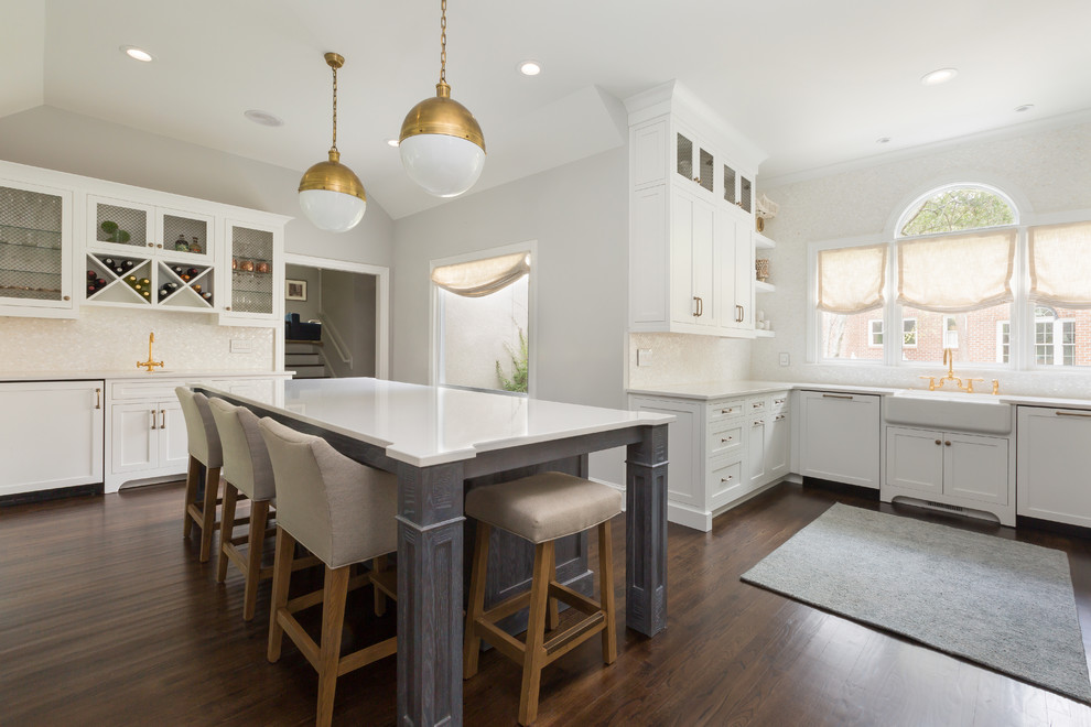 Large transitional single-wall open plan kitchen in Charleston with a farmhouse sink, shaker cabinets, white cabinets, white splashback, dark hardwood floors, with island, marble benchtops, ceramic splashback and panelled appliances.