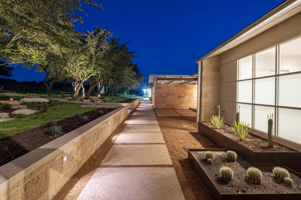Photo of a large modern front yard garden in Austin with concrete pavers.