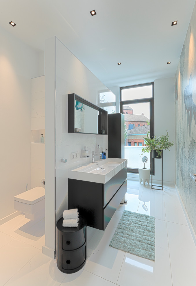 Bild på ett funkis badrum med dusch, med svarta skåp, en kantlös dusch, en vägghängd toalettstol, klinkergolv i keramik, ett väggmonterat handfat och vitt golv