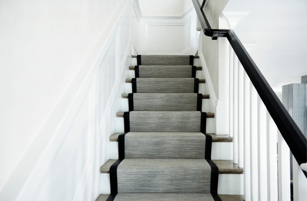 This is an example of a mid-sized contemporary carpeted straight staircase in New York with wood risers and wood railing.
