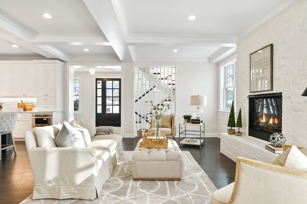 Inspiration for a large modern open concept living room in Minneapolis with white walls, dark hardwood floors, a standard fireplace, a brick fireplace surround, no tv, brown floor, coffered and brick walls.