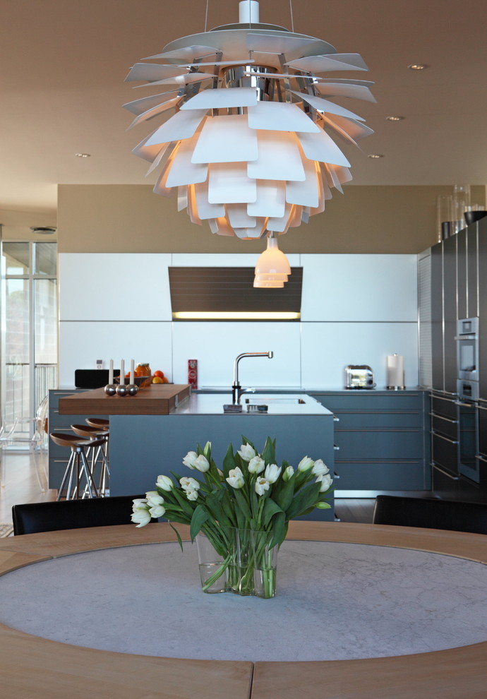 This is an example of a contemporary eat-in kitchen in Austin with flat-panel cabinets and blue cabinets.