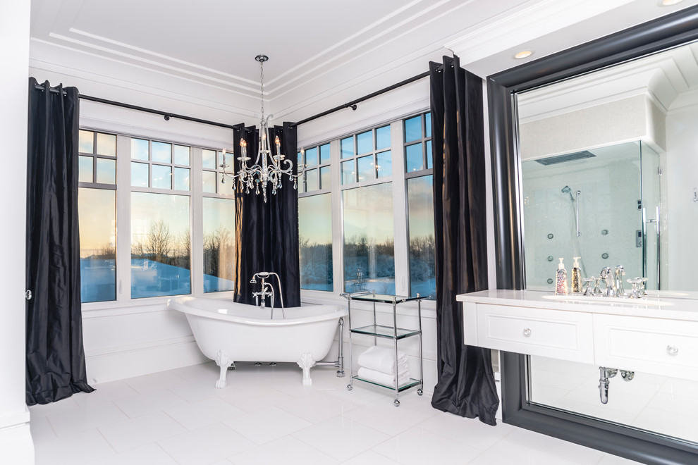 Inspiration for a large contemporary master bathroom in Edmonton with a drop-in sink, beaded inset cabinets, white cabinets, solid surface benchtops, a claw-foot tub, white tile, ceramic tile, ceramic floors and white walls.