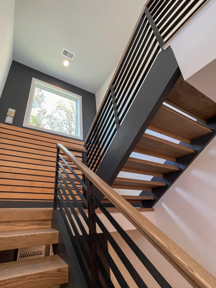 Photo of a large contemporary wood straight staircase in DC Metro with mixed railing and panelled walls.