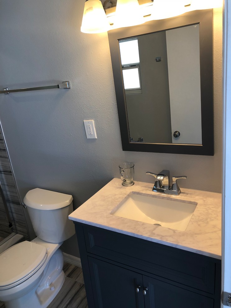 Design ideas for a mid-sized contemporary 3/4 bathroom in Orlando with recessed-panel cabinets, grey cabinets, an alcove shower, a two-piece toilet, beige tile, porcelain tile, grey walls, porcelain floors, an undermount sink, quartzite benchtops, beige floor, white benchtops and a sliding shower screen.