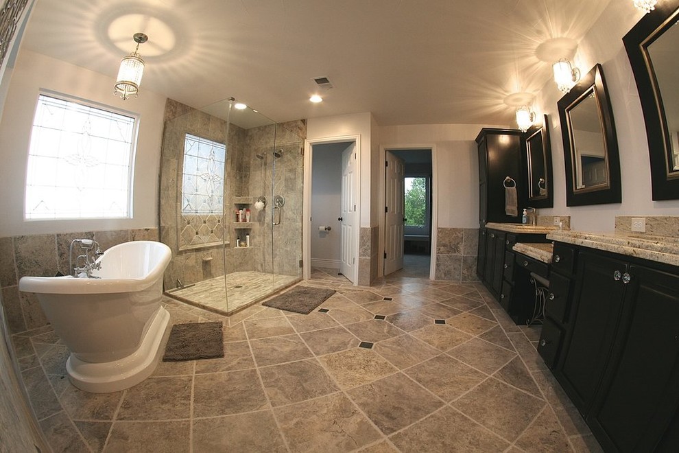 Inspiration for a large master gray tile and ceramic tile porcelain tile freestanding bathtub remodel in Denver with recessed-panel cabinets, black cabinets, granite countertops, a two-piece toilet and an undermount sink