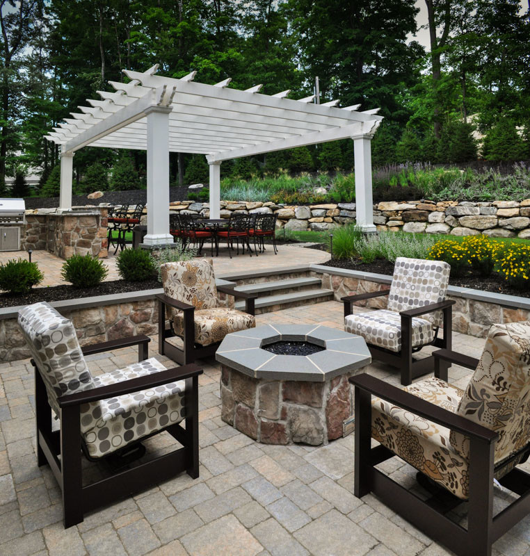 Photo of a traditional backyard patio in New York with a pergola and a fire feature.