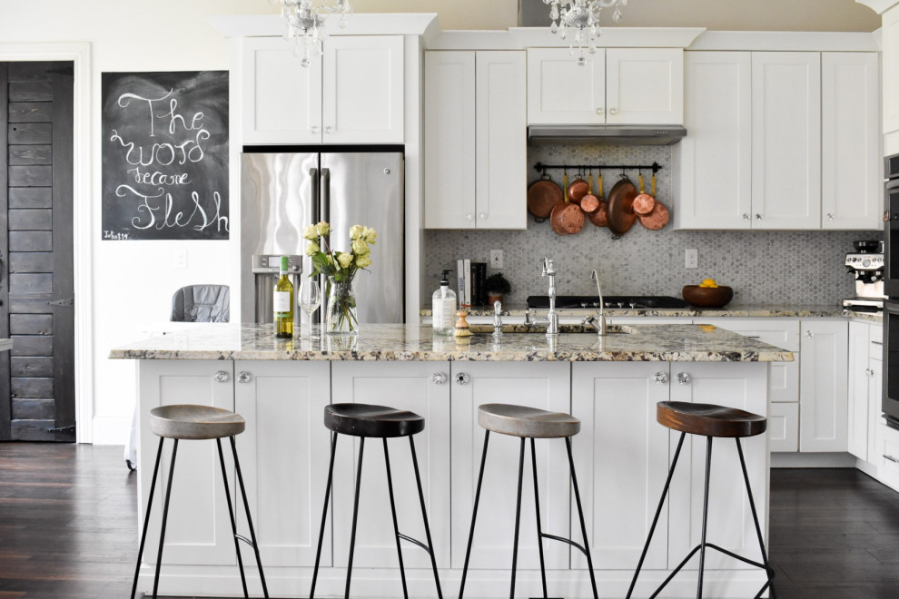 Inspiration for a transitional l-shaped dark wood floor and brown floor kitchen remodel with an undermount sink, shaker cabinets, white cabinets, gray backsplash, mosaic tile backsplash, stainless steel appliances, an island and multicolored countertops