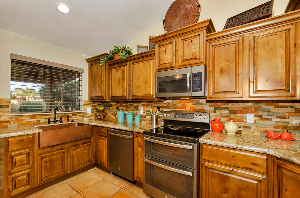 Inspiration for a mid-sized rustic u-shaped porcelain tile home design remodel in Phoenix with a farmhouse sink, raised-panel cabinets, light wood cabinets, granite countertops, orange backsplash, mosaic tile backsplash, stainless steel appliances and no island