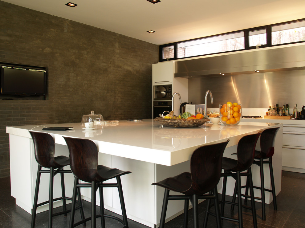 Inspiration for a contemporary kitchen in Amsterdam with white cabinets and metallic splashback.