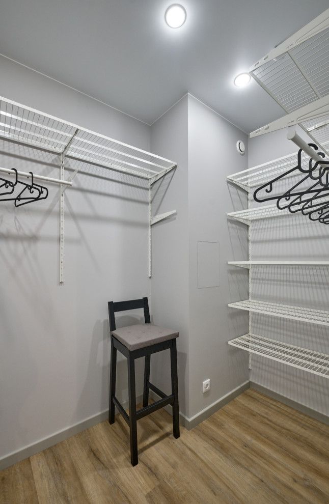 Example of a small trendy gender-neutral vinyl floor and brown floor walk-in closet design in Moscow