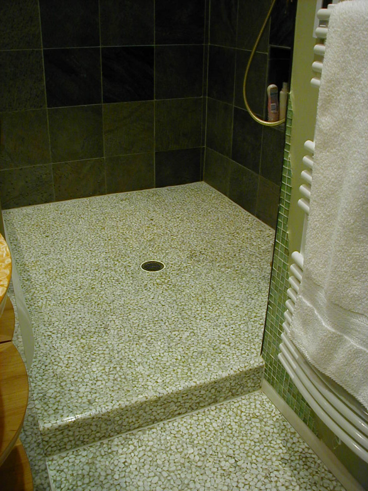 Inspiration for a mid-sized contemporary master wet room bathroom in Other with furniture-like cabinets, light wood cabinets, a drop-in tub, a wall-mount toilet, green tile, slate, green walls, pebble tile floors, a vessel sink, wood benchtops, white floor, an open shower, a niche, a single vanity and a freestanding vanity.