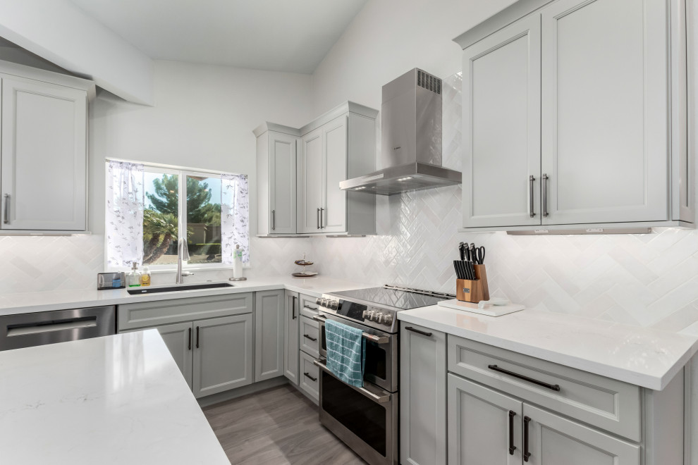 Example of a mid-sized transitional porcelain tile and gray floor eat-in kitchen design in Phoenix with an undermount sink, shaker cabinets, gray cabinets, quartz countertops, white backsplash, subway tile backsplash, stainless steel appliances, an island and white countertops