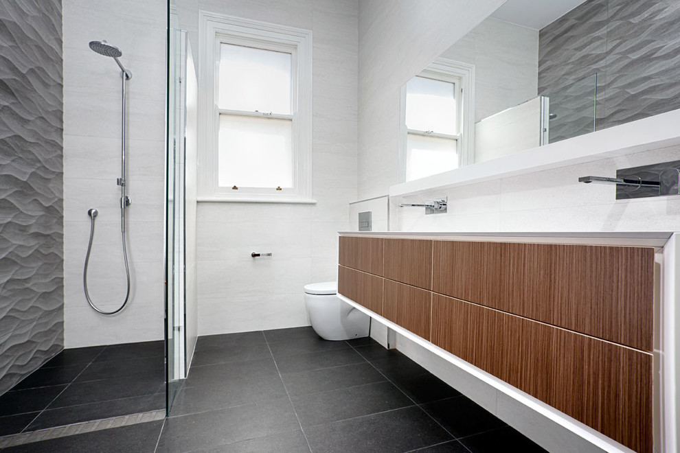 Design ideas for a mid-sized modern master bathroom in Perth with a wall-mount sink, medium wood cabinets, engineered quartz benchtops, a corner shower, a wall-mount toilet, white tile, ceramic tile, grey walls and porcelain floors.