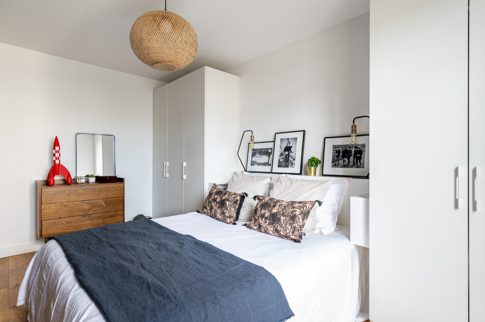 Bedroom - large contemporary master medium tone wood floor bedroom idea in Paris with white walls