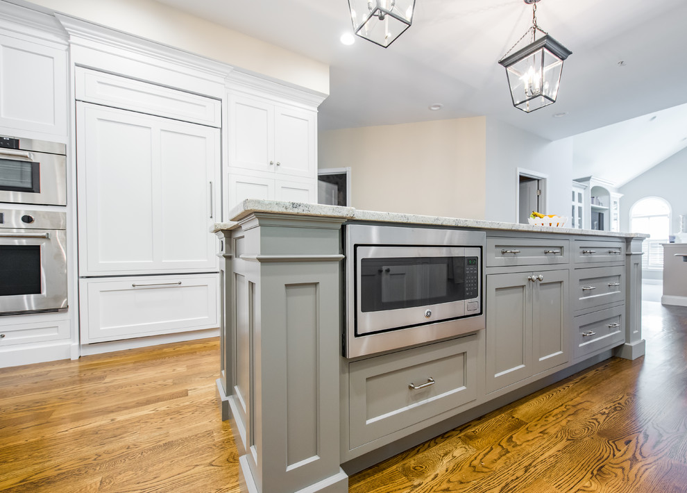 Mid-sized traditional u-shaped separate kitchen in Boston with an undermount sink, shaker cabinets, stainless steel appliances, dark hardwood floors, with island, white cabinets, granite benchtops, beige splashback and porcelain splashback.