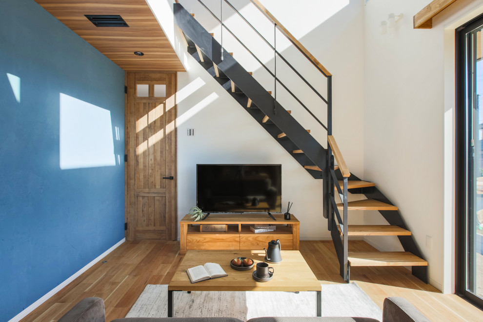Свежая идея для дизайна: открытая гостиная комната среднего размера в скандинавском стиле с синими стенами, паркетным полом среднего тона, отдельно стоящим телевизором, коричневым полом, деревянным потолком и обоями на стенах - отличное фото интерьера