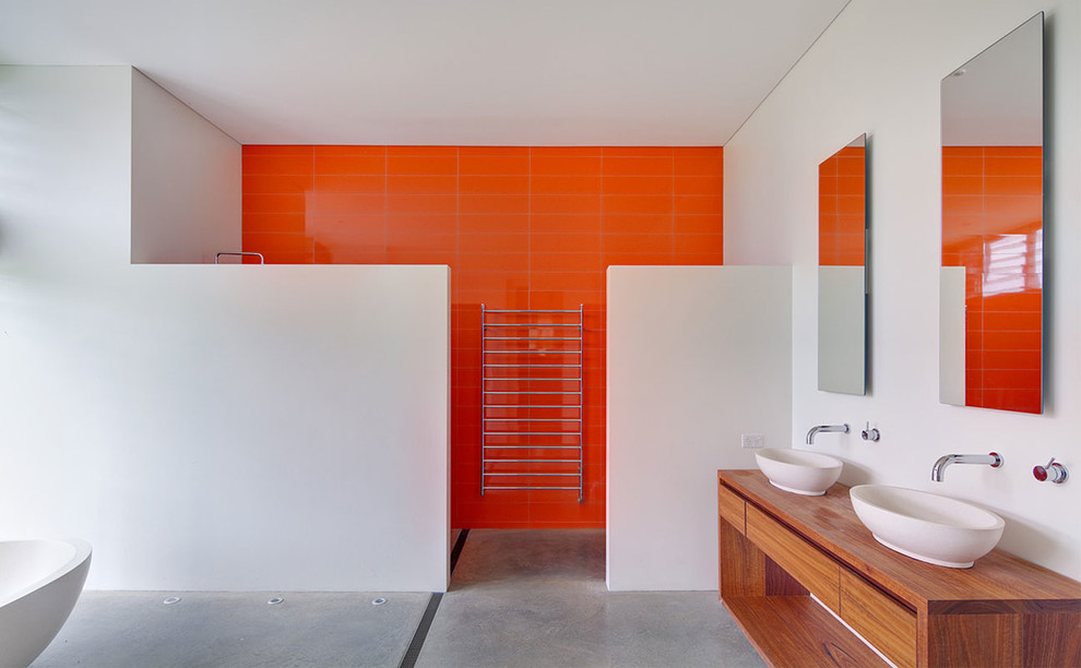 Inspiration for a contemporary bathroom in Sydney with a vessel sink, flat-panel cabinets, medium wood cabinets, wood benchtops, orange tile, ceramic tile, white walls, concrete floors, a curbless shower, grey floor and brown benchtops.