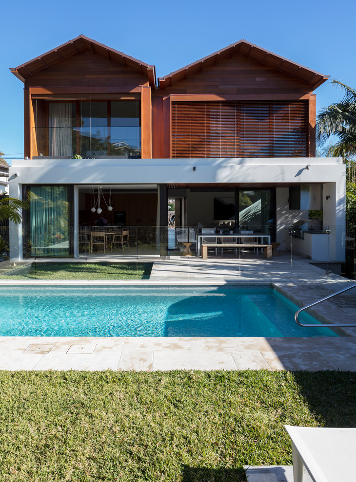 Inspiration for a contemporary backyard rectangular natural pool in Sydney with natural stone pavers.