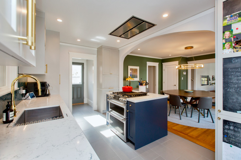 This is an example of a mid-sized transitional galley eat-in kitchen in San Francisco with an undermount sink, shaker cabinets, grey cabinets, quartz benchtops, green splashback, glass tile splashback, stainless steel appliances, porcelain floors, with island, grey floor and white benchtop.