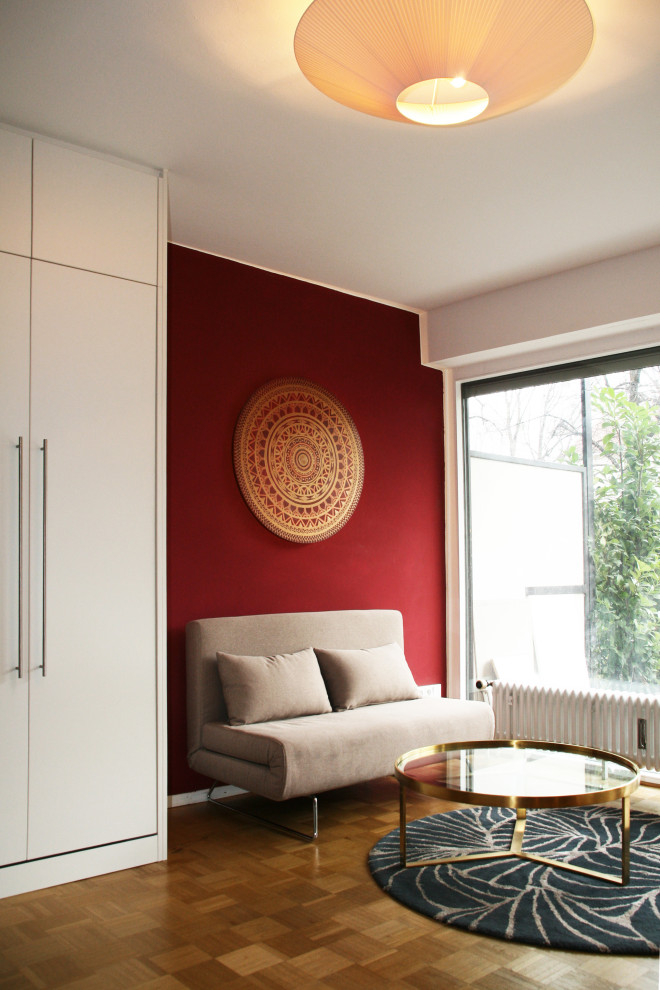 Diseño de salón abierto actual pequeño con paredes rojas, suelo de madera clara y suelo amarillo