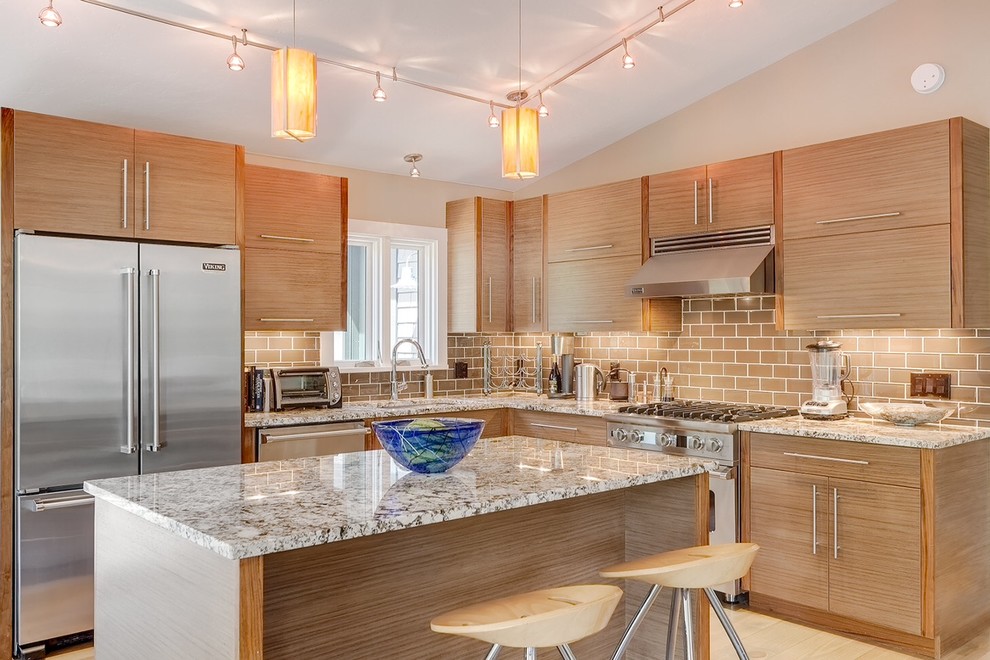 Photo of a contemporary l-shaped kitchen in Denver with flat-panel cabinets, medium wood cabinets, granite benchtops, brown splashback, subway tile splashback and stainless steel appliances.