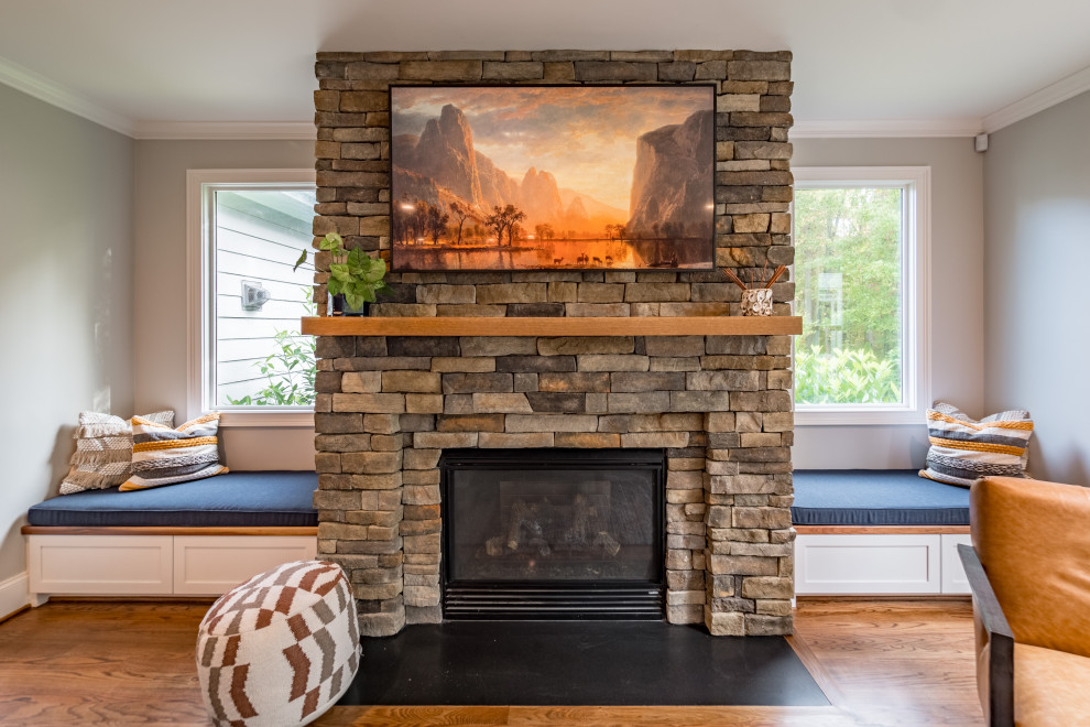Offenes Klassisches Wohnzimmer mit grauer Wandfarbe, braunem Holzboden, Kaminumrandung aus gestapelten Steinen und TV-Wand in Raleigh