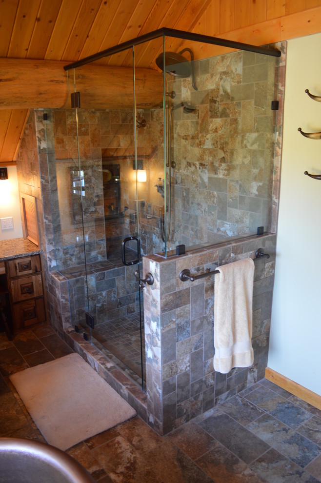 Mid-sized mountain style master multicolored tile and stone tile slate floor freestanding bathtub photo with raised-panel cabinets, medium tone wood cabinets, granite countertops and beige walls