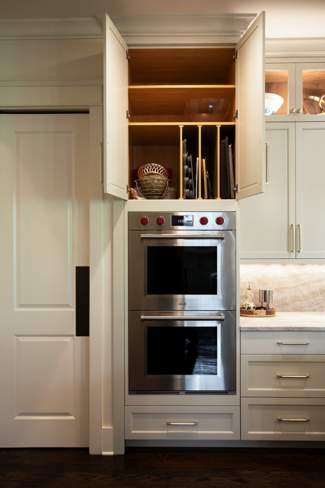 Large transitional l-shaped dark wood floor and brown floor open concept kitchen photo in Nashville with an undermount sink, beaded inset cabinets, white cabinets, quartzite countertops, beige backsplash, stone slab backsplash, stainless steel appliances, an island and beige countertops