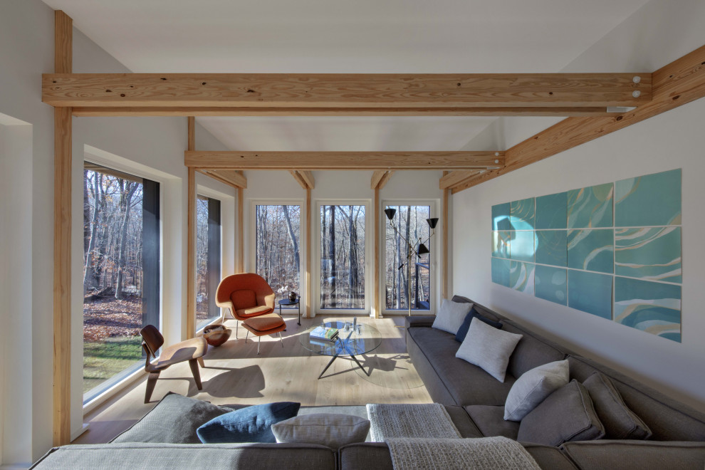 На фото: открытая гостиная комната среднего размера в стиле модернизм с белыми стенами, светлым паркетным полом и балками на потолке с