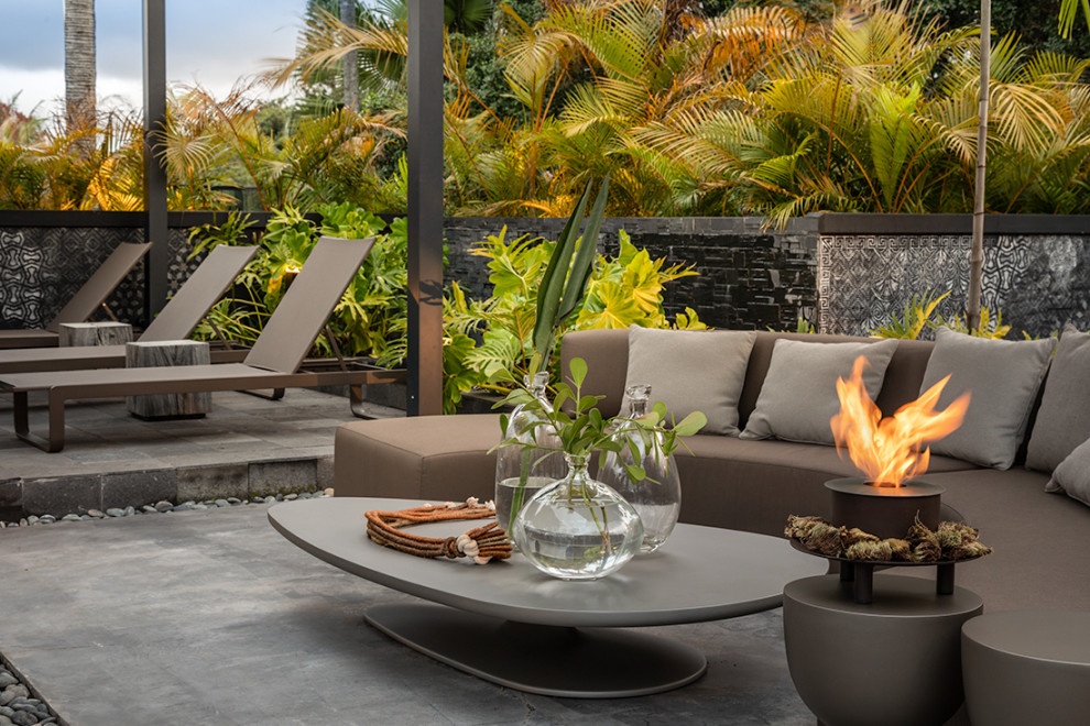 Photo of an expansive tropical rooftop and rooftop deck in Miami with with fireplace.