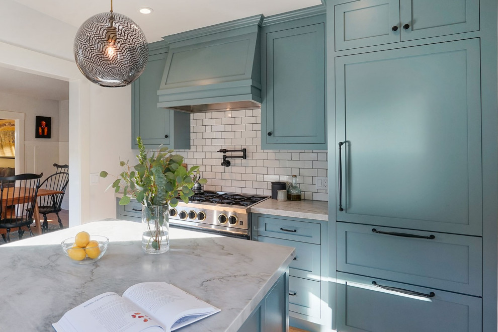 This is an example of a mid-sized transitional galley separate kitchen in San Francisco with an undermount sink, shaker cabinets, blue cabinets, quartzite benchtops, white splashback, ceramic splashback, panelled appliances, medium hardwood floors, with island, brown floor and white benchtop.