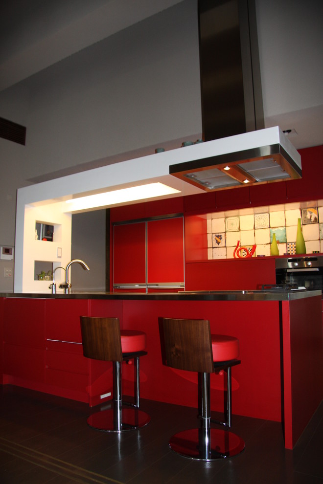 Photo of a mid-sized contemporary single-wall eat-in kitchen in Tokyo with an undermount sink, flat-panel cabinets, red cabinets, stainless steel benchtops, multi-coloured splashback, porcelain splashback, panelled appliances, medium hardwood floors and with island.
