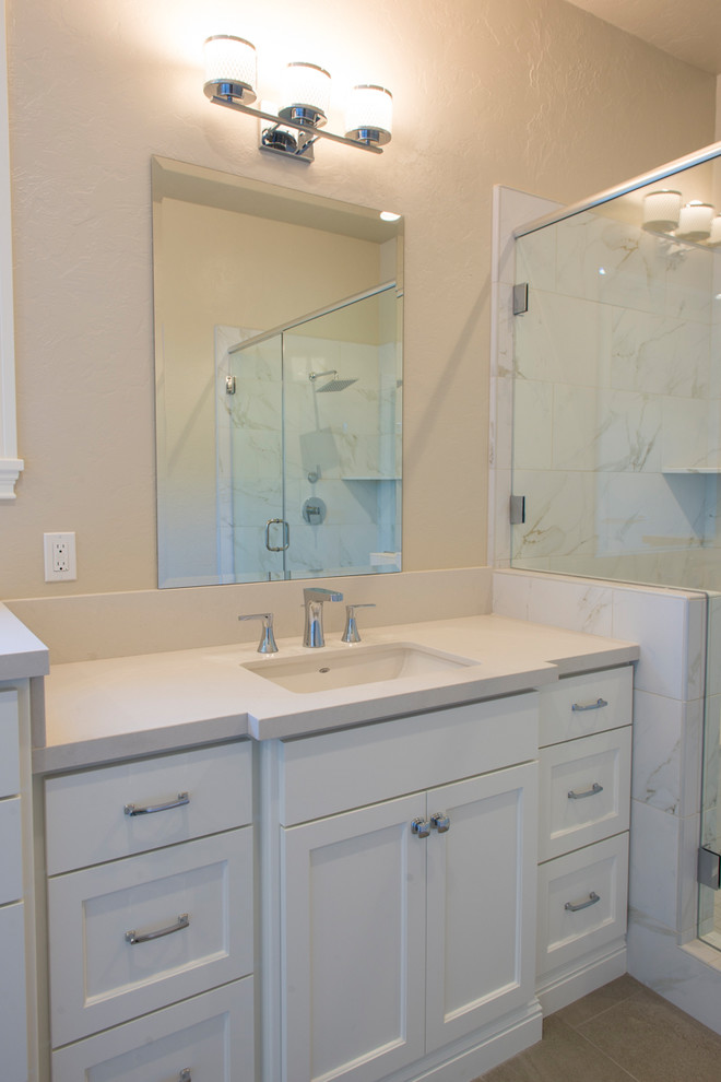 This is an example of a large transitional master bathroom in Sacramento with shaker cabinets, white cabinets, a freestanding tub, an open shower, a one-piece toilet, beige walls, ceramic floors, an undermount sink, granite benchtops, grey floor and a hinged shower door.