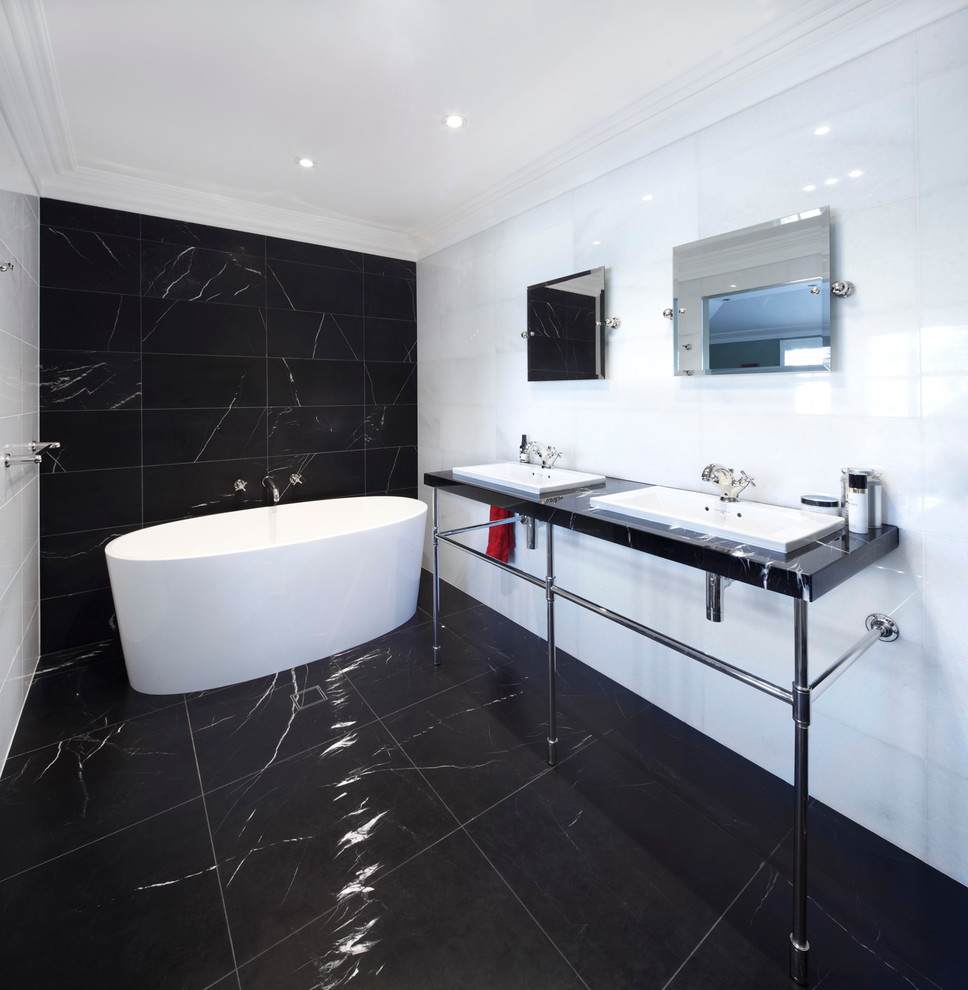 Photo of a large contemporary master wet room bathroom in Sydney with a freestanding tub, black tile, black and white tile, white tile, marble floors, a console sink, black floor and a hinged shower door.