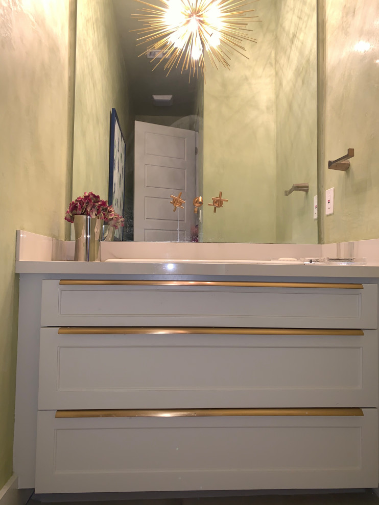 Inredning av ett klassiskt vit vitt toalett, med släta luckor, grå skåp, en toalettstol med separat cisternkåpa, grön kakel, spegel istället för kakel, gröna väggar, klinkergolv i porslin, ett undermonterad handfat, bänkskiva i kvarts och grått golv